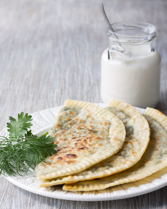 Кутабы с зеленью на тарелке с мацони